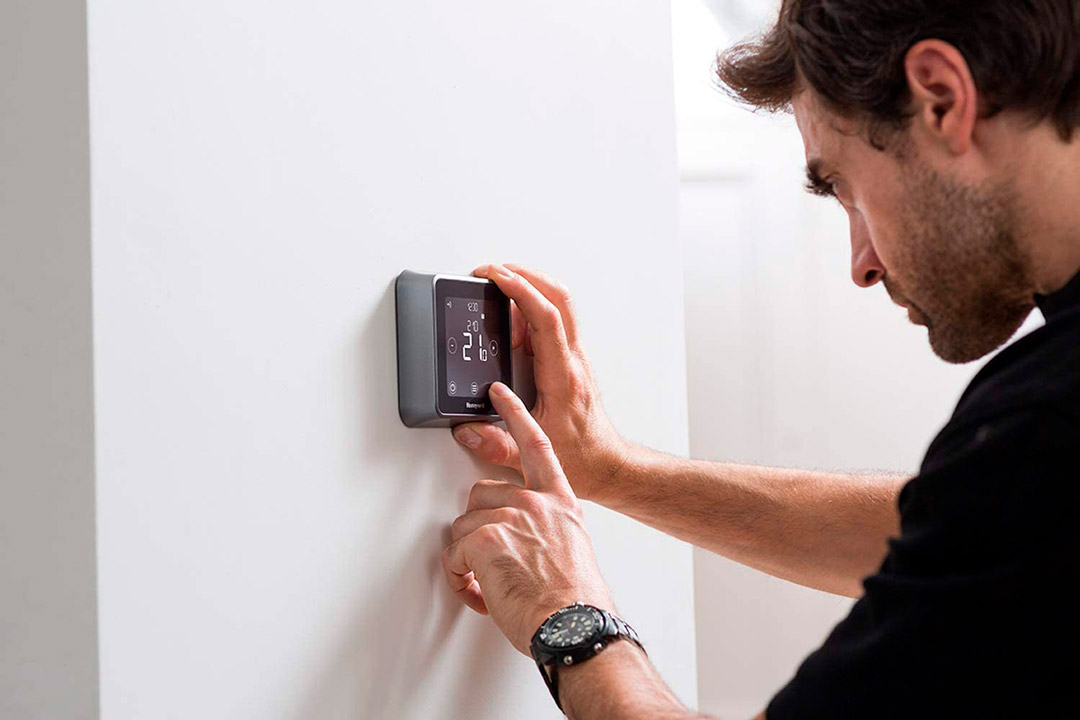 hombre gestionando pantalla táctil termostato honeywell