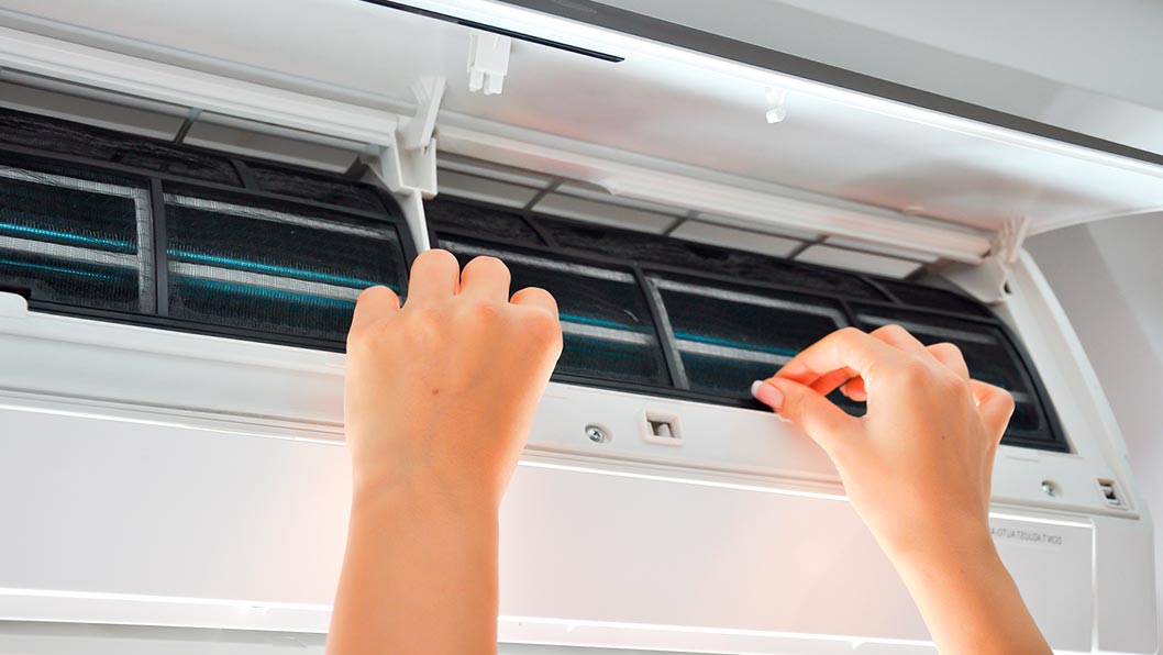 Manos de una mujer realizando la limpieza del aire acondicionado