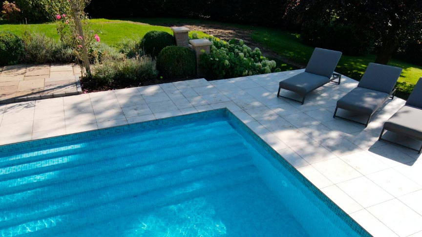 entrada a la piscina en el jardín y unas tumbonas