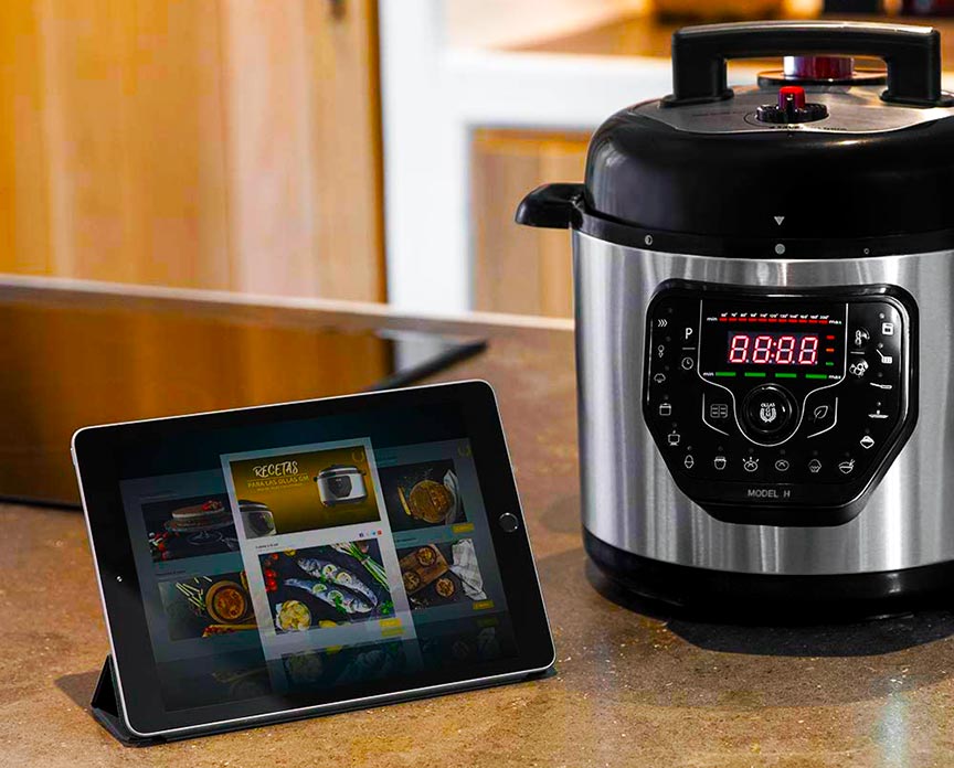 una de las Ollas GM junto una tablet mostrando recetas