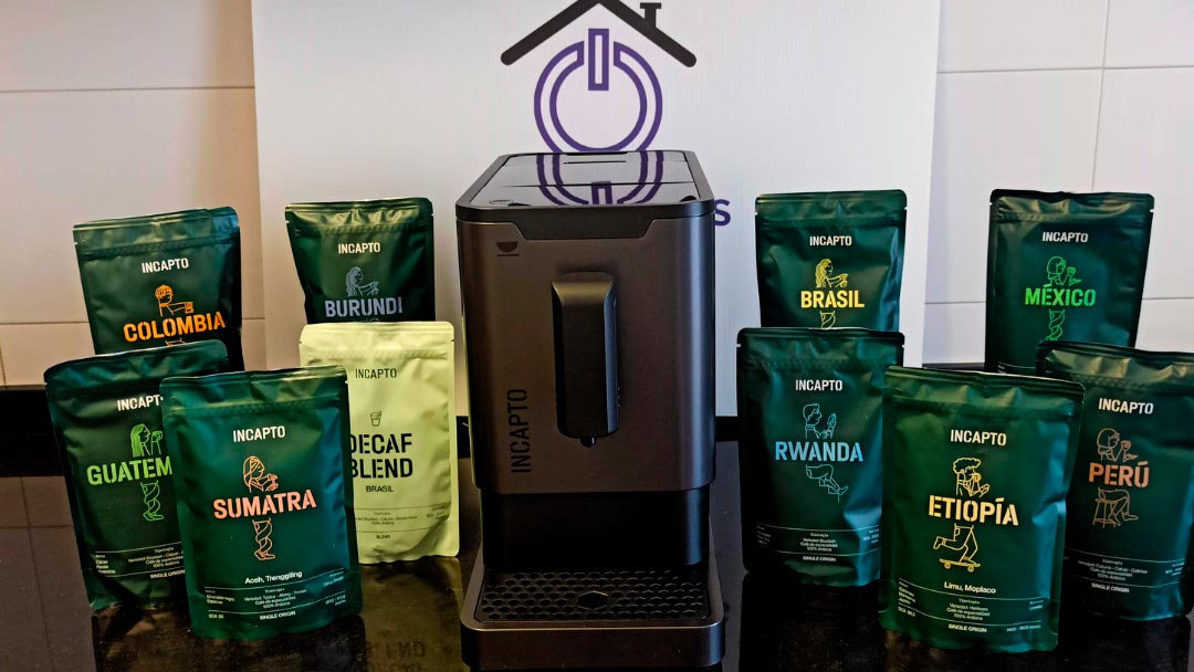 cafetera Incapto negra rodeada de cafés