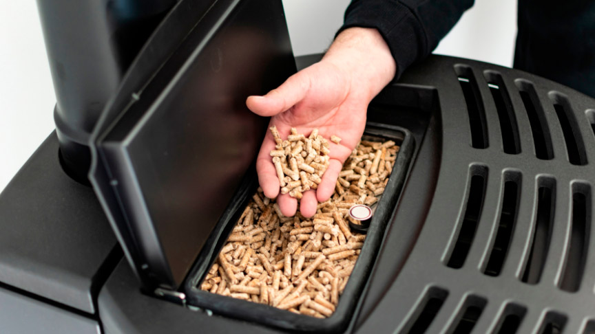 introducciendo pellets en el compartimento de la estufa