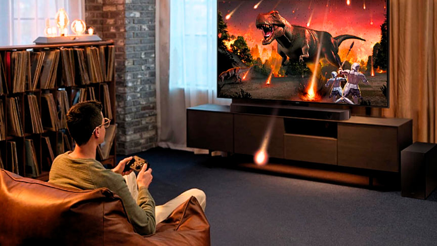 chico jugando a un videojuego en el televisor con la barra de sonido Samsung