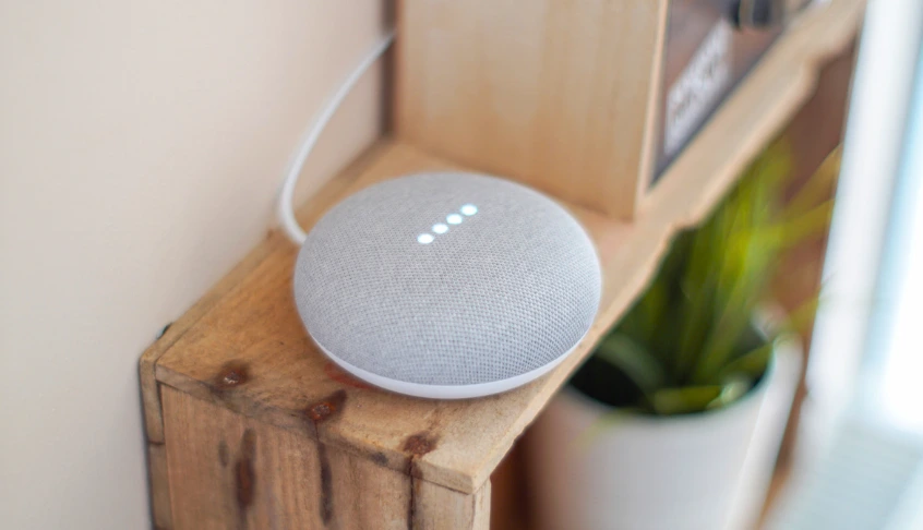 altavoz inteligente blanco sobre una estantería de madera